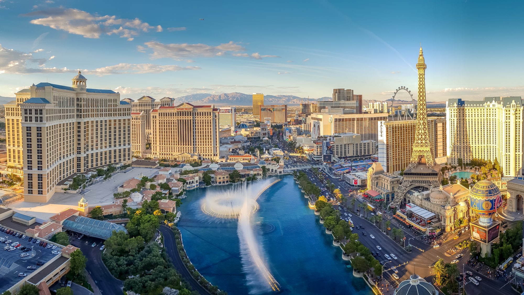 Aerial view of the Las Vegas Strip featuring the Bellagio Fountain, surrounding hotels, casinos, and the distant mountains under a clear sky—a stunning contrast to Carson City Estate Planning expertise that ensures your legacy remains intact.